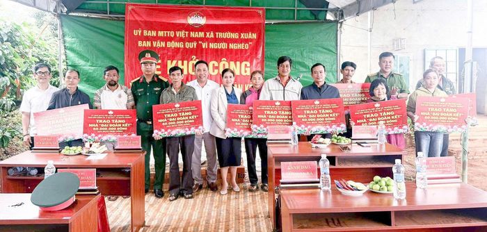 Đại diện chính quyền địa phương trao bảng tượng trưng kinh phí hỗ trợ xây dựng nhà ở cho các hộ khó khăn