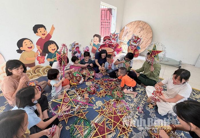 Cán bộ Trung tâm Bảo trợ xã hội Ninh Bình hướng dẫn các em nhỏ làm đèn trung thu chuẩn bị cho đêm hội trăng rằm.