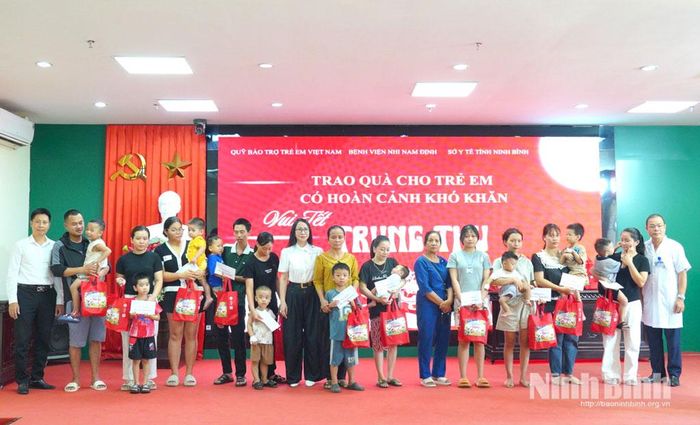 Lãnh đạo Chi cục Dân số và Trẻ em tỉnh tặng quà cho bệnh nhi có hoàn cảnh khó khăn đang điều trị tại Bệnh viện Nhi Nam Định. Ảnh: Diệu Linh