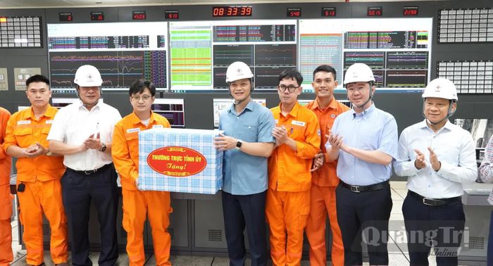 Đồng chí Vương Quốc Tuấn, Bí thư Tỉnh ủy và các đồng chí lãnh đạo tỉnh tặng quà cán bộ, kỹ sư đang làm việc tại Nhà máy nhiệt điện Quảng Trạch I - Ảnh: Q.V