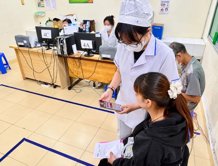 Hướng dẫn hỗ trợ người dân sử dụng sổ sức khỏe điện tử. (Ảnh: Trung tâm Y tế Châu Đốc)