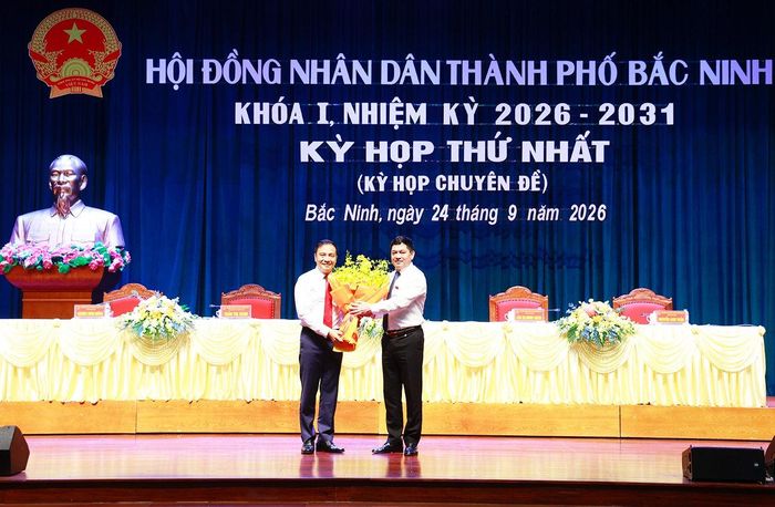 Bí thư Thành uỷ Bắc Ninh Nguyễn Hồng Thái tặng hoa chúc mừng tân Phó Chủ tịch UBND thành phố Bắc Ninh Đào Thanh Trường. Ảnh: Dương Thuỷ