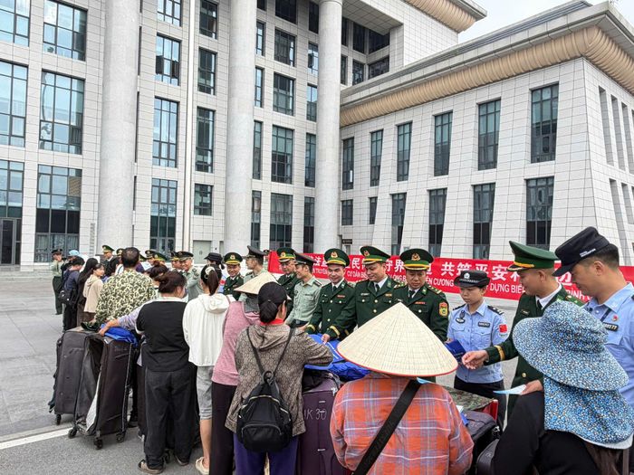 Lực lượng biên phòng 2 bên phối hợp tuyên truyền pháp luật cho hành khách và cư dân biên giới. Ảnh: Trung Dũng