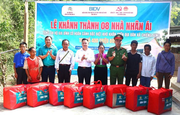 Các đại biểu trao biểu trưng và quà mừng tân gia tặng các hộ gia đình khó khăn.