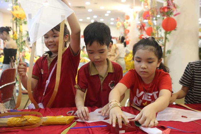Trẻ em thích thú làm diều giấy.