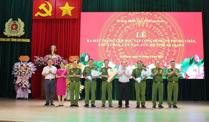Các đại biểu tặng hoa chúc mừng Tổ điều hành, quản lý Trung tâm học tập cộng đồng về PCCC và CNCH tỉnh An Giang.