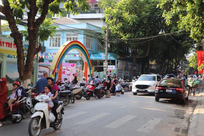 Phụ huynh tập trung đón trẻ trước cổng Phân hiệu Mầm non 1/6 vào giờ cao điểm, khiến không gian lưu thông bị thu hẹp. 
