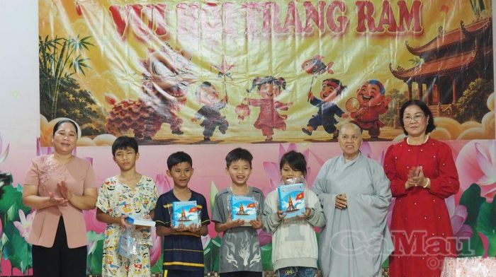 Bà Nguyễn Thu Tư, Giám đốc Sở Dân tộc và Tôn giáo (bìa trái) và Ni sư Thích Nữ Diệu Chánh, Phó Ban Trị sự, Trưởng Phân ban Ni giới Ban Trị sự Phật giáo tỉnh Cà Mau, kiêm Trụ trì chùa Kim Sơn trao quà Trung thu cho các em nhỏ.