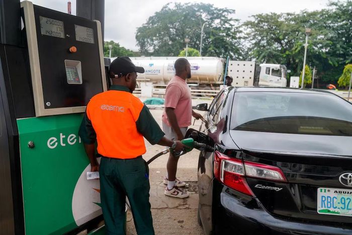 Nhân viên bơm nhiên liệu cho ô tô tại một trạm xăng ở Abuja, Nigeria, ngày 21/9/2026. Ảnh: Reuters/Marvellous Durowaiye.