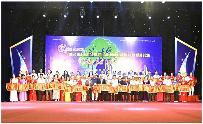 Đại diện hội người cao tuổi các xã, phường lên nhận cờ lưu niệm của ban tổ chức tặng. Ảnh phú cường