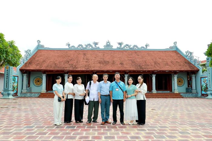 Các đại biểu chụp ảnh lưu niệm trước đình Vân La. Ảnh: Xuân Hòa.