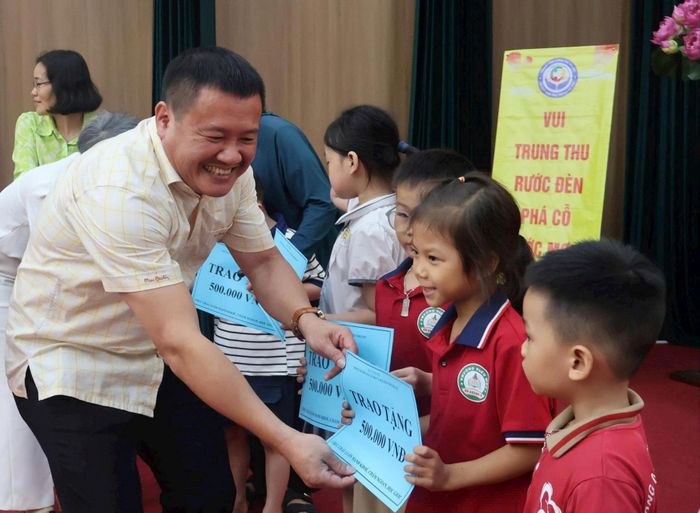 Giám đốc Trung tâm Công tác xã hội và Quỹ Bảo trợ trẻ em Hà Nội Nguyễn Văn Triệu trao kinh phí và quà cho các em . Ảnh: Phạm Ban