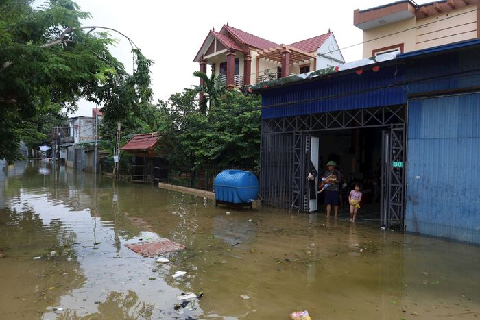 Nhiều ngôi nhà của người dân thôn Đồng Chiêm (xã Mỹ Đức) còn ngập sâu trong nước lũ lẫn rác thải. Ảnh: Kim Nhuệ
