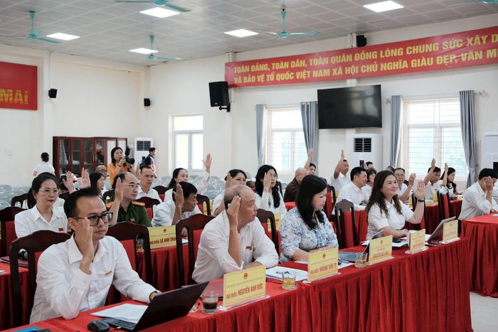 Các đại biểu HĐND biểu quyết thông qua Nghị quyết Về việc thành lập, tổ chức lại các phòng chuyên môn thuộc UBND phường Tương Mai. Ảnh: PV