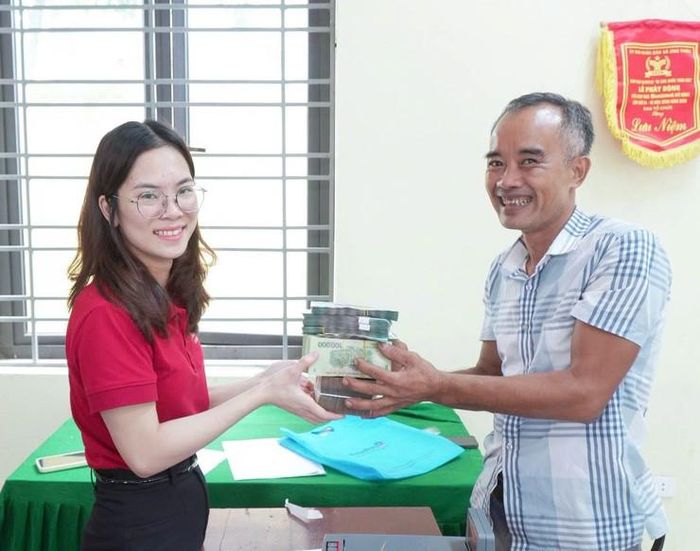 Người dân phấn khởi nhận diện hỗ trợ bồi thường giải phóng mặt bằng thực hiện quốc lộ 21B. Ảnh: Cao Hồng