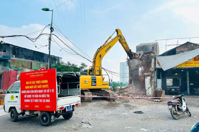 Lực lượng chức năng tháo dỡ công trình của hộ dân đã nhận tiền bồi thường, bàn giao mặt bằng. Ảnh: Trần Oanh.