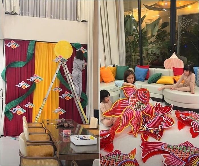Góc check-in mang đậm không khí dân gian với phông rèm đỏ vàng, hình ảnh trăng tròn và những đám mây ngũ sắc dần được hoàn thiện dưới bàn tay khéo léo của Vân Trang. Ở ngay trong phòng khách, nữ diễn viên cùng các con tỉ mỉ lắp ráp từng chiếc đèn cá chép khổng lồ để chuẩn bị cho buổi tối phá cỗ.