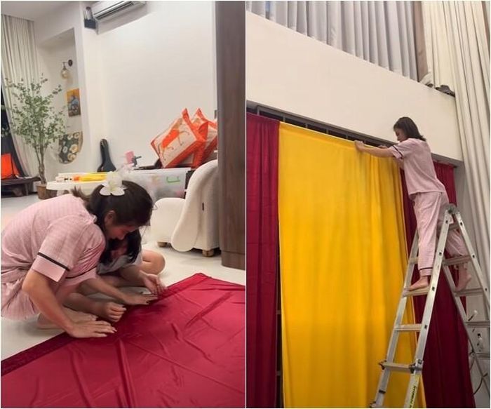 Để hoàn thiện phông nền Trung thu hoành tráng, nữ diễn viên không ngần ngại tự tay đo đạc, may vá từng tấm vải rèm đỏ - vàng và trực tiếp trèo thang cao để treo trang trí. Sự tận tụy và tỉ mỉ của người mẹ 9x khiến ai nấy nhìn vào cũng phải trầm trồ, ngưỡng mộ.