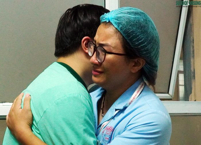 Nhân viên y tế tại BVĐK Xanh Pôn ôm người thân của nữ nhân viên y tế B.H.A trước thời khắc thiêng liêng. Ảnh: LB