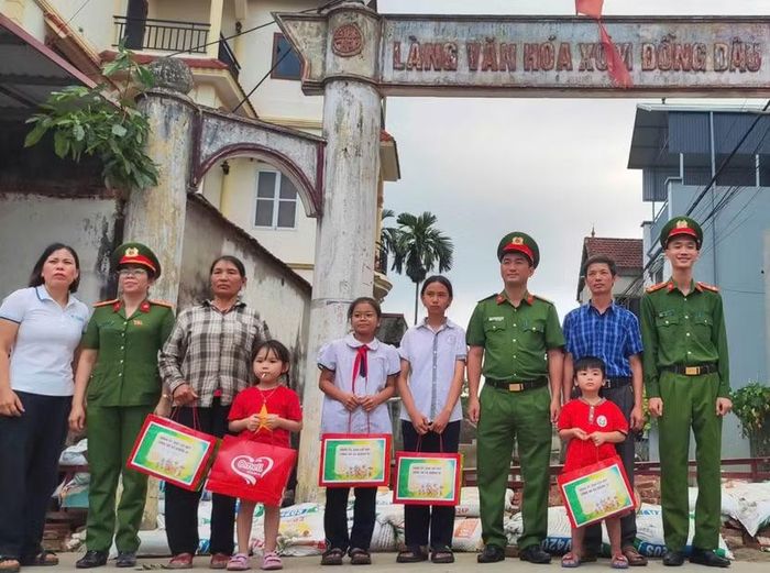 Cán bộ, chiến sĩ Công an xã Quảng Bị, Hà Nội trao quà Trung thu cho các em nhỏ trước cổng Làng văn hóa xóm Đồng Dâu, thôn Ninh Kiều