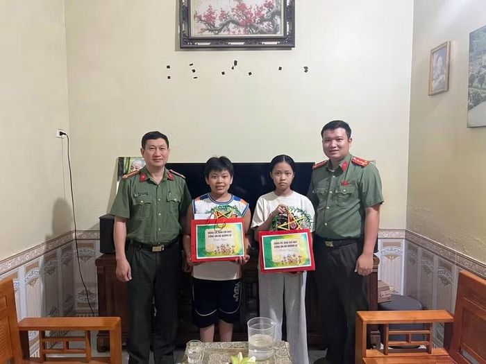 Niềm vui của hai em nhỏ vùng ngập lụt khi đón nhận phần quà và chiếc đèn ông sao từ các chiến sĩ công an.