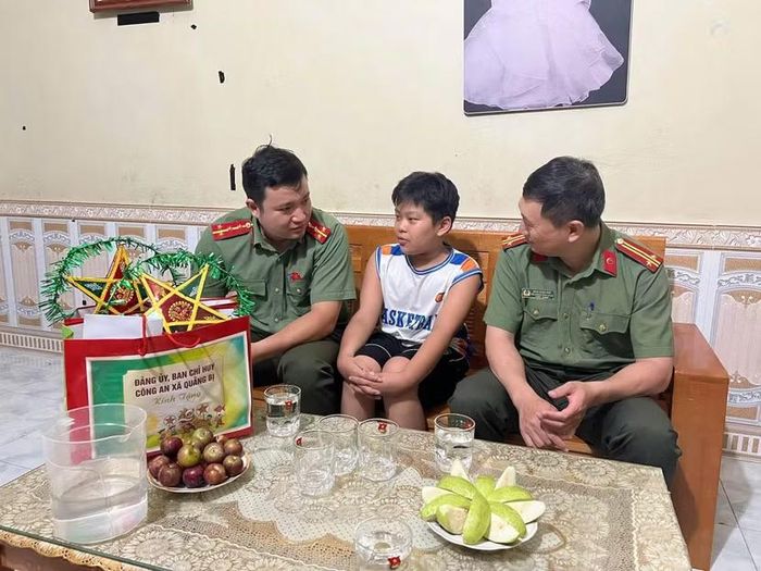 Cán bộ Công an xã Quảng Bị trò chuyện, động viên việc học tập của các em nhỏ trong gian nhà vừa qua đợt ngập úng.