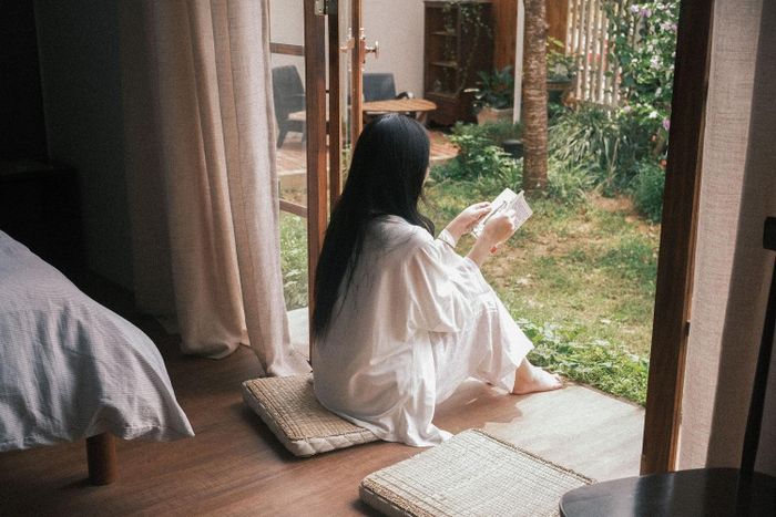  Du khách ngồi đọc sách trước hiên của homestay. Ảnh: Hoài Nam. 