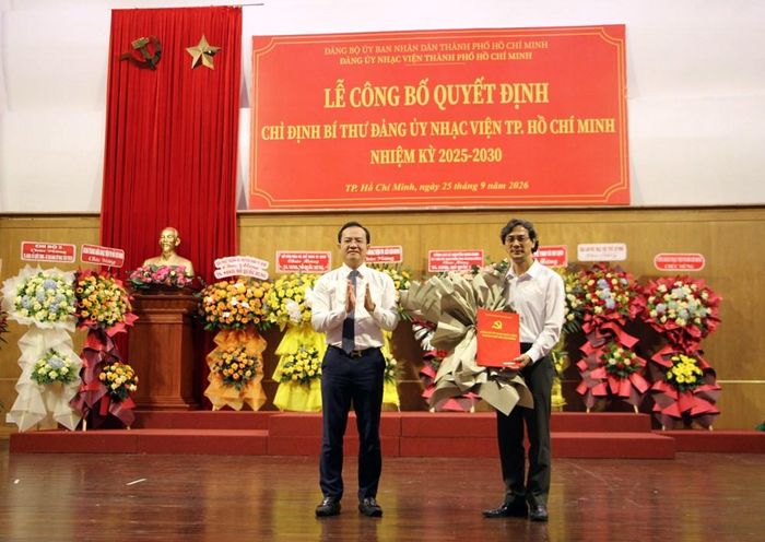 Ông Huỳnh Tân Định, Phó Bí thư Đảng ủy, Chủ nhiệm Ủy ban Kiểm tra Đảng ủy UBND TP.HCM trao Quyết định và tặng hoa đến ông Trần Minh Đặng