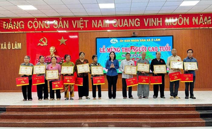 Đại diện UBND xã Ô Lâm trao Bằng mừng thọ và quà cho người cao tuổi