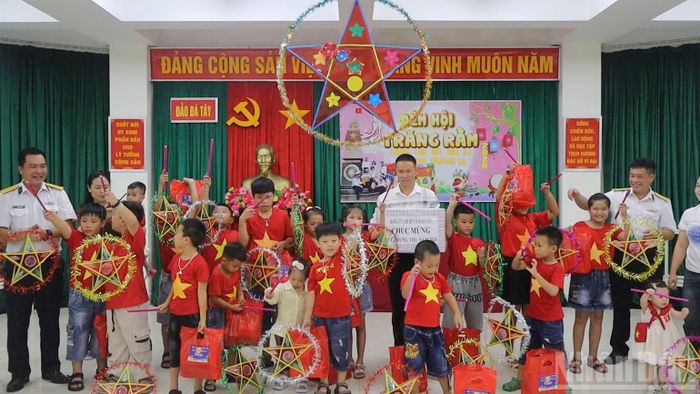 Cán bộ, chiến sĩ đảo Đá Tây tặng quà các cháu thiếu nhi. (Ảnh: THÀNH VŨ)