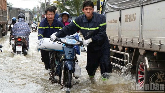 Lực lượng Công an thành phố Đồng Nai hỗ trợ người dân qua tuyến đường bị ngập tại xã Bình Minh.