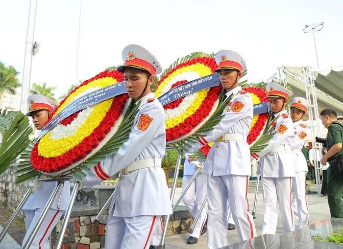 Chiến sĩ Bộ Chỉ huy quân sự tỉnh Điện Biên rước vòng hoa kính viếng hương hồn liệt sĩ trong Lễ truy điệu, an táng hài cốt liệt sĩ tại Nghĩa trang Liệt sĩ Tông Khao. (Ảnh: LÊ LAN)