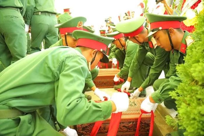 Các chiến sĩ thực hiện hạ huyệt các hài cốt liệt sĩ. (Ảnh: LÊ LAN)
