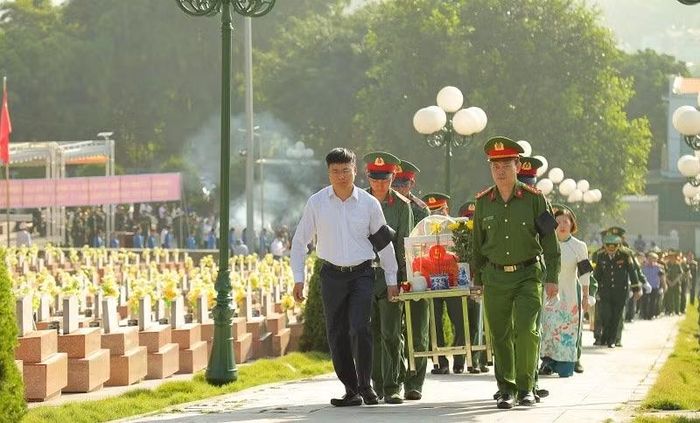 Đại biểu là lãnh đạo các ngành rước linh cữu hài cốt liệt sĩ về nơi an táng tại Nghĩa trang Liệt sĩ Tông Khao. (Ảnh: LÊ LAN)