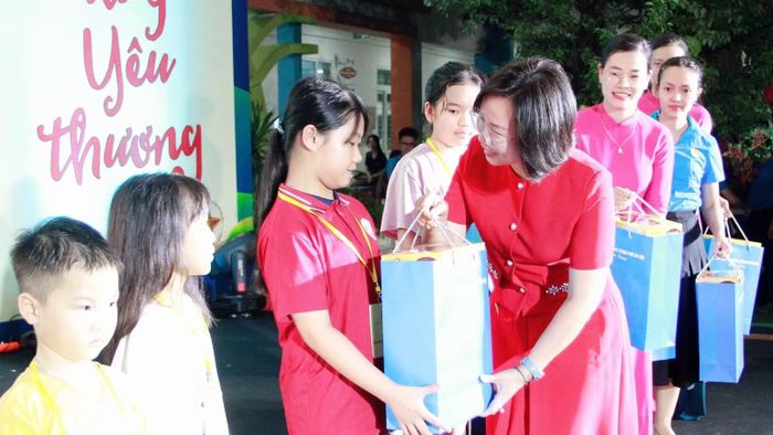 Chủ tịch Ủy ban Mặt trận Tổ quốc Việt Nam Thành phố Hà Nội Bùi Huyền Mai tặng quà con em công nhân, lao động. (Ảnh: NGỌC ÁNH)