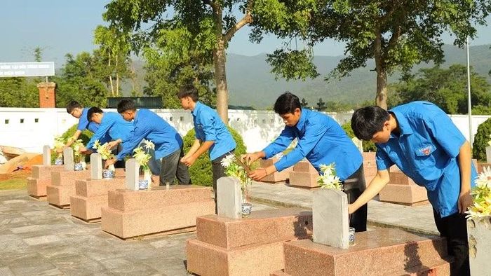 Học sinh Trường trung học phổ thông Thanh Nưa dâng hương trên phần mộ liệt sĩ tại Nghĩa trang Liệt sĩ Tông Khao. (Ảnh: LÊ LAN)