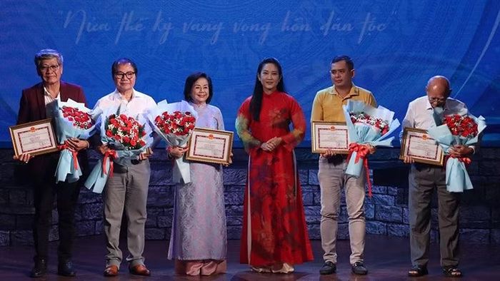 Nghệ sĩ Nhân dân Nguyễn Thị Thanh Thúy, Phó Giám đốc Sở Văn hóa và Thể thao Thành phố Hồ Chí Minh trao giấy khen, hoa tri ân tặng đại diện là các vị nguyên trưởng đoàn. (Ảnh: HỒNG HẠNH)
