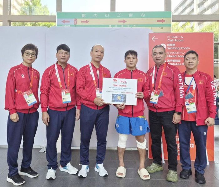Võ sĩ Đinh Văn Tâm (thứ ba, từ phải sang) nhận thưởng cho thành tích huy chương bạc. Ảnh: BÙI LƯỢNG