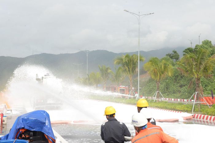  Các lực lượng xử lý tình huống cháy trong quá trình thu gom dầu tràn tại ven bờ vịnh.  