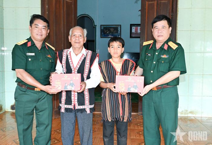 Đại tá Hà Văn Nam, Bí thư Đảng ủy, Phó đoàn trưởng Đoàn Kinh tế - Quốc phòng 74 và cán bộ đơn vị trao quà Trung thu tặng già làng Rơ Mah Duẽn và cháu của già làng.