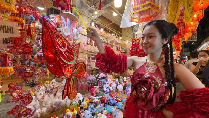  Bạn sinh viên Chu Thị Thiên thích thú với chiếc lồng đèn cá chép dán giấy kiếng truyền thống. Ảnh: ĐÌNH DƯ 
