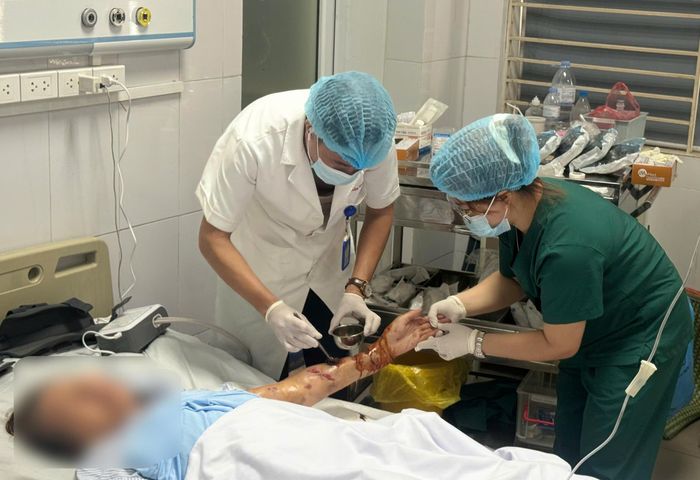 Bác sĩ điều trị cho bệnh nhân bị chó nhà cắn. Ảnh: ĐẶNG THANH