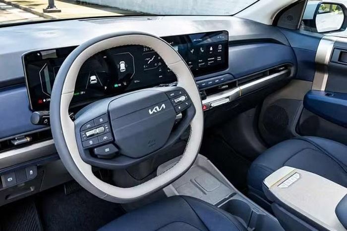 Khoang cabin của Kia EV3 được bố trí tinh tế với sự kết hợp màu sắc trẻ trung. Điểm nhấn trung tâm là cụm màn hình rộng liền khối kích thước 30 inch, bao gồm hai màn hình 12 inch cho bảng đồng hồ và giải trí, kẹp giữa là màn hình điều khiển điều hòa 5 inch.