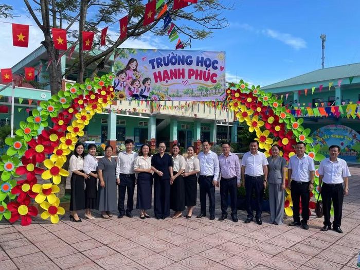 Thứ trưởng Nguyễn Thị Quyên Thanh chụp ảnh lưu niệm cùng đoàn công tác và cán bộ, giáo viên Trường Mầm non Tân Lập. Ảnh: Hà An.