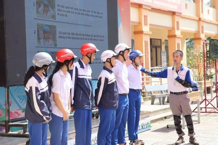 Học sinh được phổ biến đội mũ bảo hiểm đúng cách.