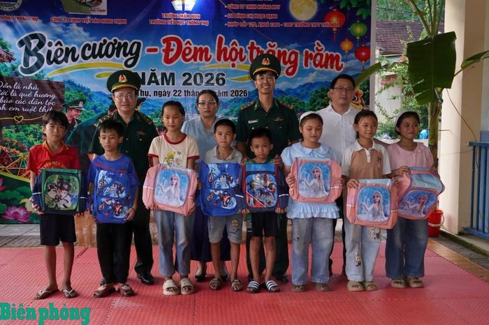Cán bộ Đồn Biên phòng Thông Thụ và đại diện địa phương trao tặng cặp sách cho các cháu có hoàn cảnh gia đình khó khăn trên địa bàn. Ảnh: Anh Bách