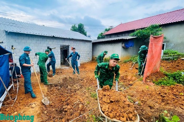 Cán bộ, chiến sĩ Đồn Biên phòng cửa khẩu Chi Ma tham gia ngày công giúp người dân xóa nhà tạm, nhà dột nát. Ảnh: Lâm Thảo