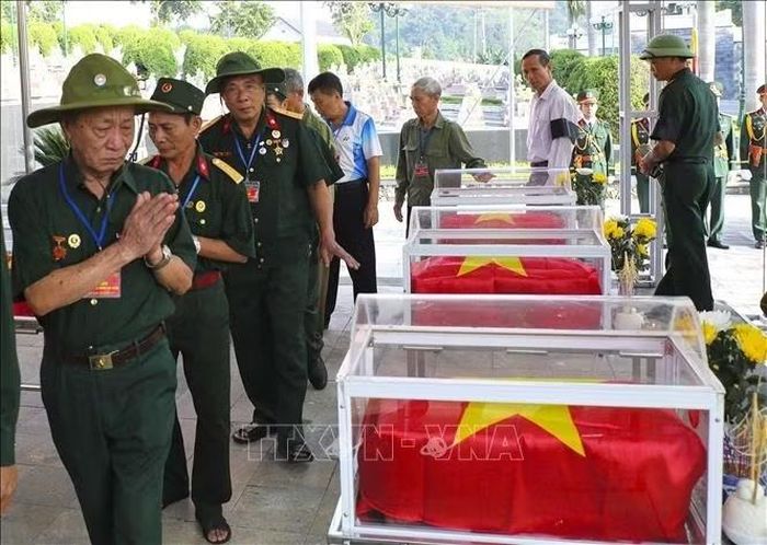 Các cựu chiến binh viếng các liệt sĩ trước khi thực hiện nghi thức an táng. Ảnh: Xuân Tư/TTXVN