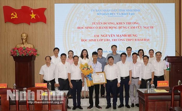 Các đại biểu chụp ảnh lưu niệm cùng em Nguyễn Mạnh Hùng. Ảnh: Báo Ninh Bình.