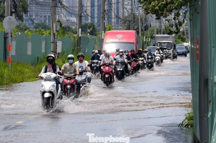 Đường Lương Định Của dài gần 500 m từ vòng xoay Trần Não đến đoạn giao với đường Tố Hữu vẫn tiếp tục ngập sâu dù giữa trưa nắng. Ảnh: Khoa Nam.